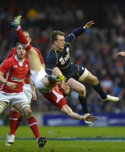 El escocés Stuart Hogg choca contra el jugador galés Leigh Halfpenny.