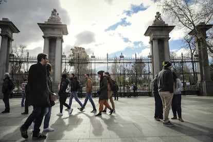 Varios viandantes pasan por delante del parque del Retiro, que permanece cerrado desde el pasado lunes.