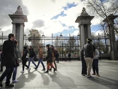 Varios viandantes pasan por delante del parque del Retiro, que permanece cerrado desde el pasado lunes.