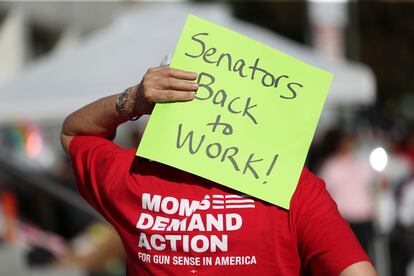 An attendee holds a sign behind their head during a rally calling for an end to the Senate Republican walkout at the Oregon State Capitol