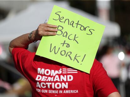 An attendee holds a sign behind their head during a rally calling for an end to the Senate Republican walkout at the Oregon State Capitol