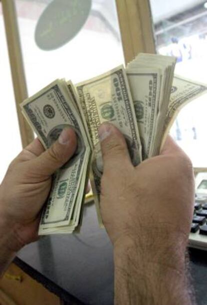 Un trabajador de una tienda de divisas cuenta unos billetes de dólar. EFE/Archivo