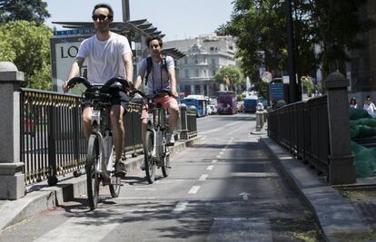 Dos ciclistas circulan en Bicimad por el carril bici de la calle Alcalá.
