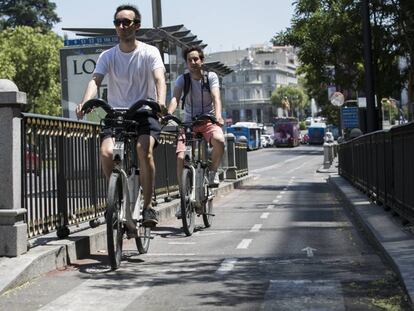Dos ciclistas circulan en Bicimad por el carril bici de la calle Alcalá. 