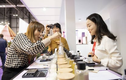 Una mujer confecciona su propia fragancia mezclando aromas en el estand de Corea del Sur.