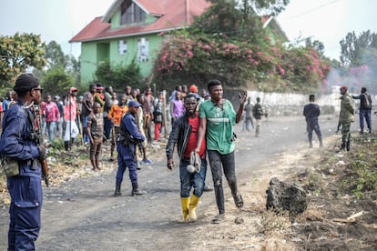Una docena de civiles y tres cascos azules de la ONU han muerto ya en las protestas que estallaron el lunes en varias ciudades del este de la República Democrática del Congo (RDC) para exigir la retirada de la misión de paz de Naciones Unidas (Monusco). Los manifestantes acusan a los 'cascos azules' de ineficiencia frente a la violencia que asola el este del país, donde operan al menos 122 grupos rebeldes. En la foto, un manifestante herido pasa junto a agentes de policía en Sake, al oeste de Goma, este miércoles.