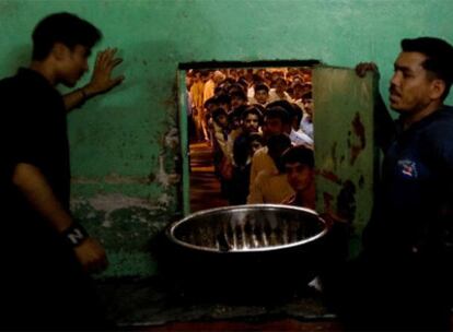 Dos voluntarios paquistaníes esperan la llegada de la comida que va a ser repartida entre la población en una mezquita de Islamabad.