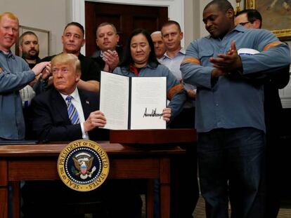 Trump firma los aranceles rodeado de trabajadores del acero y el aluminio.