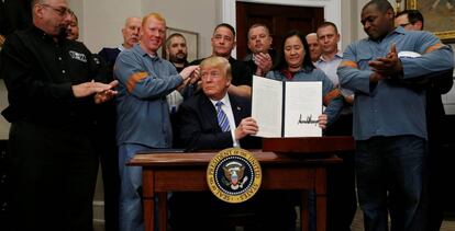 Trump firma los aranceles rodeado de trabajadores del acero y el aluminio.