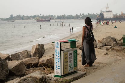 Una india mira la bahía junto a una papelera cercana al Fuerte de Cochin durante la celebración de la bienal de arte.