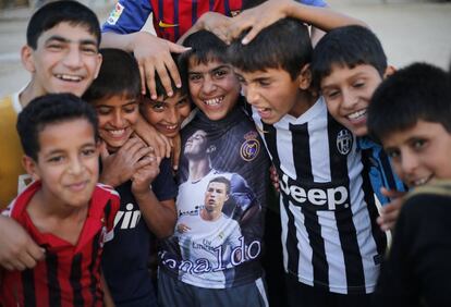 Niños chiítas que juegan al fútbol, posan con sus camisetas, en la ciudad de Bagdad (Irak).