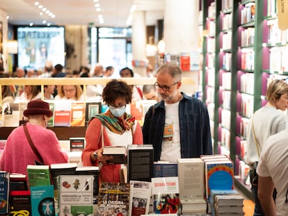 Varias personas buscan libros en una librería de Barcelona.