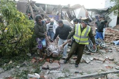 Un policía chileno y varios vecinos sacan el cadáver de un hombre de una casa totalmente destruida por el terremoto en Talca, a 275 kilómetros al sur de Santiago.