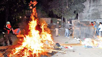 Varios manifestantes queman basura de un contenedor, a metros de los accesos a la planta impresora.