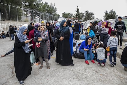 O governo está acelerando as transferências e anunciou que até o final do ano moverá cerca de 20.000 pessoas. Na foto, um grupo de pessoas espera no portão do campo a chegada de ônibus que os levarão ao porto de Mitilene para serem transferidos para a Grécia continental.