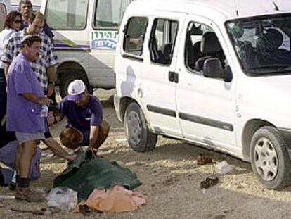 Un grupo de israelíes, junto al cadaver de la mujer asesinada hoy en Cisjordania.