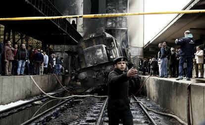 Un policía da indicaciones frente a un tren accidentado dentro de la estación de tren Ramsis en El Cairo (Egipto), el 27 de febrero. Un funcionario médico egipcio ha declarado que al menos 20 personas murieron y decenas han resultado heridas.