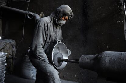 Un trabajador afgano pule una olla de metal en un taller de aluminio. Unas cien personas trabajan en la fábrica de Herat.
