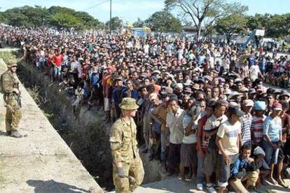 Soldados australianos vigilan a los ciudadanos que aguardan la distribución de alimentos en Dili.