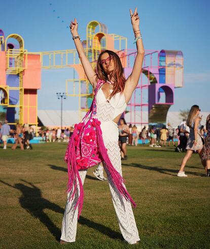 La modelo Alessandra Ambrosio llevó un mono blanco de estilo boho con aberturas laterales en la cintura, una de las tendencias de esta primavera, combinado con un maxibolso fucsia de flecos.