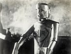 'Eric the robot at the model engineering exhibition'. L'automate radioguide Eric (concu en 1928 par WH RICHARDS et construit par l'ingenieur REFFELL d'apres le modele de Karel CAPEK (1890-1938) dans sa piece R.U.R pour Rossum's Universal Robots créée à Prague en janvier 1921, dans laquelle il emploie, pour la première fois, le mot robot). Photographie anonyme pour une carte postale de 1928. ©Collection IM/KHAR BIN E-TA PABOR (Album)