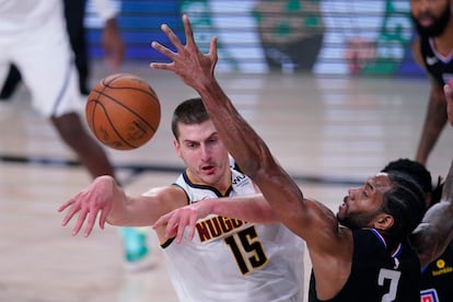 Jokic realiza un pase, ante Kawhi Leonard.