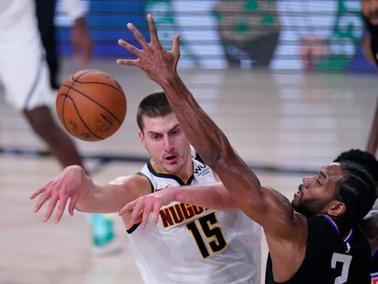 Jokic realiza un pase, ante Kawhi Leonard.