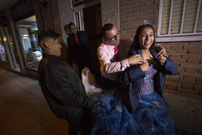 Bernardo protege de la fría noche madrileña a su hija. Tradicionalmente las fiestas de quinceañera en Colombia se celebraban cerrando la calle y montando allí la bulla. "Pero también allá han cambiado y ahora se hacen más en salones", explica Dadiana, la madre de la niña.