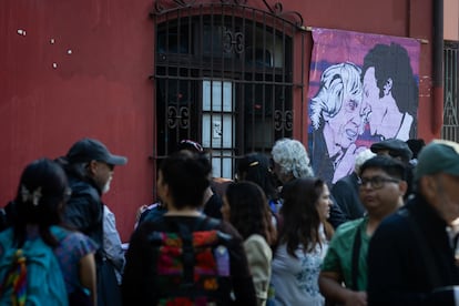 El domingo al atardecer se abría un campo de arte, imaginación y símbolos en donde una marioneta de Víctor Jara recorría el Estadio Chile. El mismo estadio que lo golpeó y lo vio morir, el mismo recinto en donde escribió sus últimas palabras. Sin embargo, a este Víctor de marioneta ya no lo embarga el espanto, sino que cobró vida acompañado de un mar de gente alegre y su guitarra. A la misma hora, su amada compañera Joan Turner, partía a los 96 años. En la imagen, cientos de personas reunidas afuera de la Escuela de Danza Espiral, en Santiago (Chile), en donde se realizó este miércoles el velorio de Joan Turner, para presentarle sus respetos. 