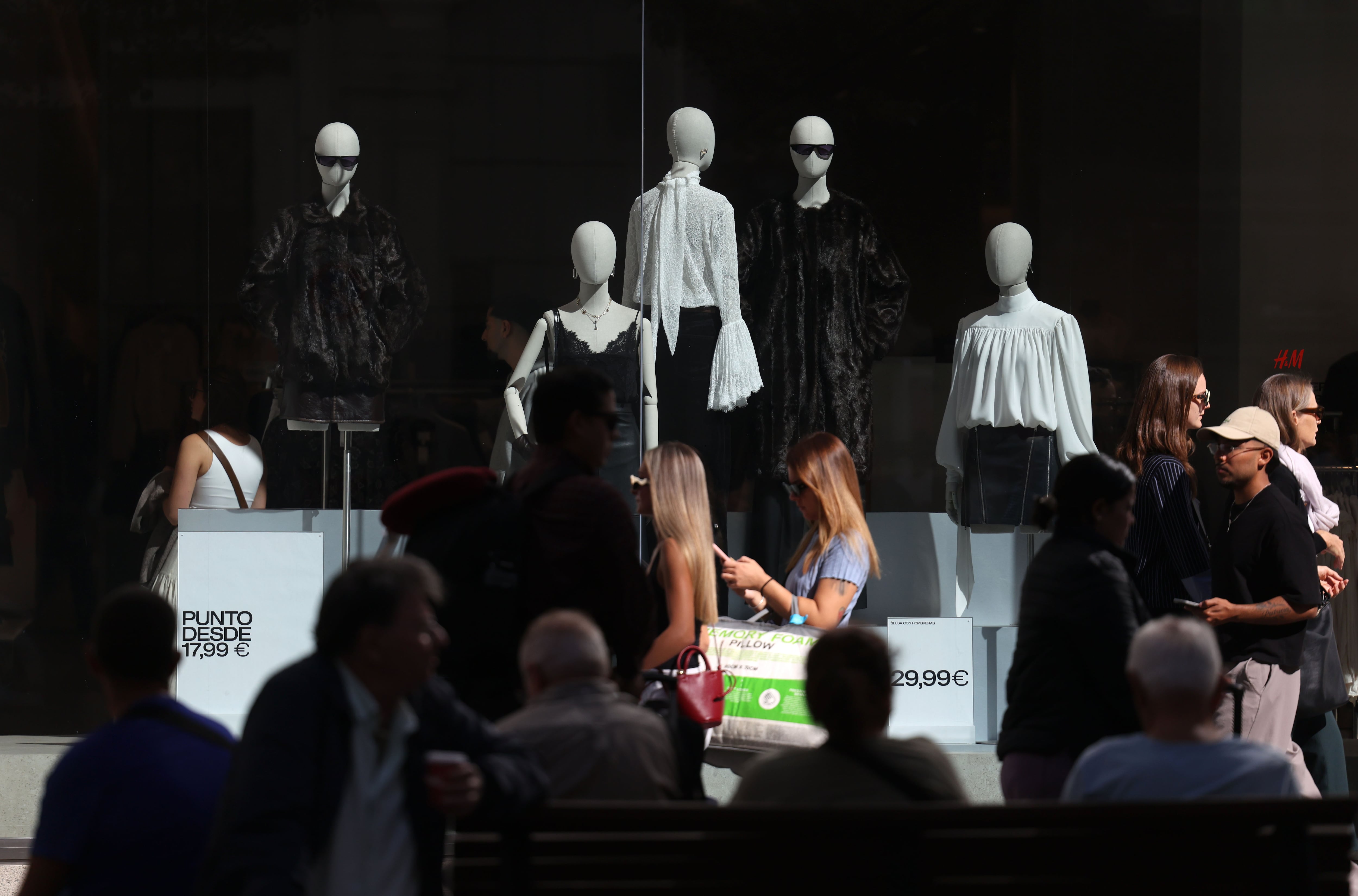 Varias personas paseaban ayer ante los escaparates de comercios en el centro de Madrid.