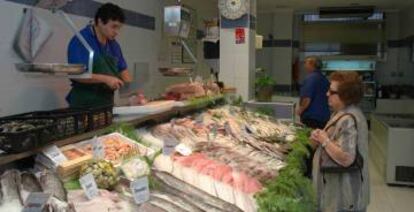 Una mujer compra en una pescadería.