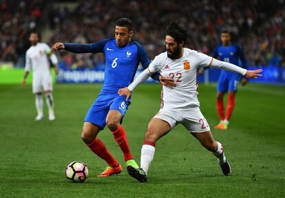 Corentin Tolisso (izquierda), de la selección de Francia, es presionado por Isco