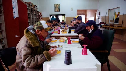 Un grupo de usuarios come en el centro barrial Antonio Gil, en Buenos Aires.