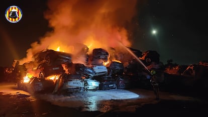 Bomberos durante la extinción del incendio en una campa de coches siniestrados en Catarroja, en una imagen cedida.