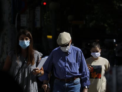 Varias personas con mascarilla caminan por una calle de Córdoba.