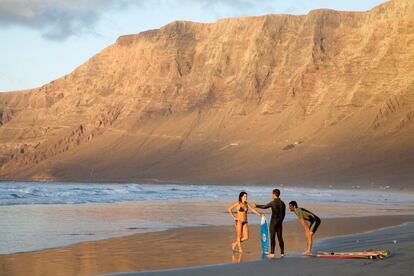 Surferos en el gran arenal de Famara, en Lanzarote.