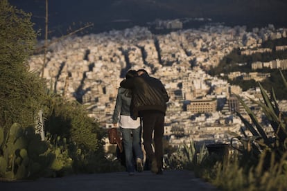 Un hombre besa a una mujer mientras caminan por una calle de Atenas (Grecia), el 10 de abril.