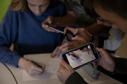 Varios alumnos usan sus teléfonos móviles durante una clase en un instituto de Terrassa.