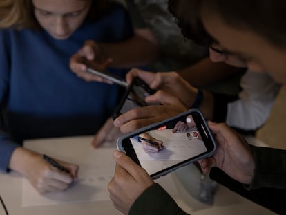 Varios alumnos usan sus teléfonos móviles durante una clase en un instituto de Terrassa.