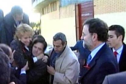 Rajoy observa cómo varias personas ayudan a Esperanza Aguirre, que sonríe, a salir de la aeronave siniestrada.