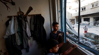 Dos chicos palestinos miran por la ventana de una clase de un colegio de la UNRWA en Jan Yunis, este viernes.
