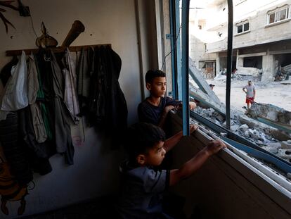 Dos chicos palestinos miran por la ventana de una clase de un colegio de la UNRWA en Jan Yunis, este viernes.