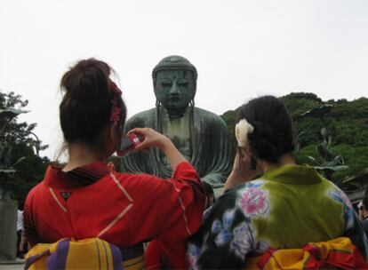 Dos mujeres ataviadas con quimonos fotografían al gran Buda de Kamakura.