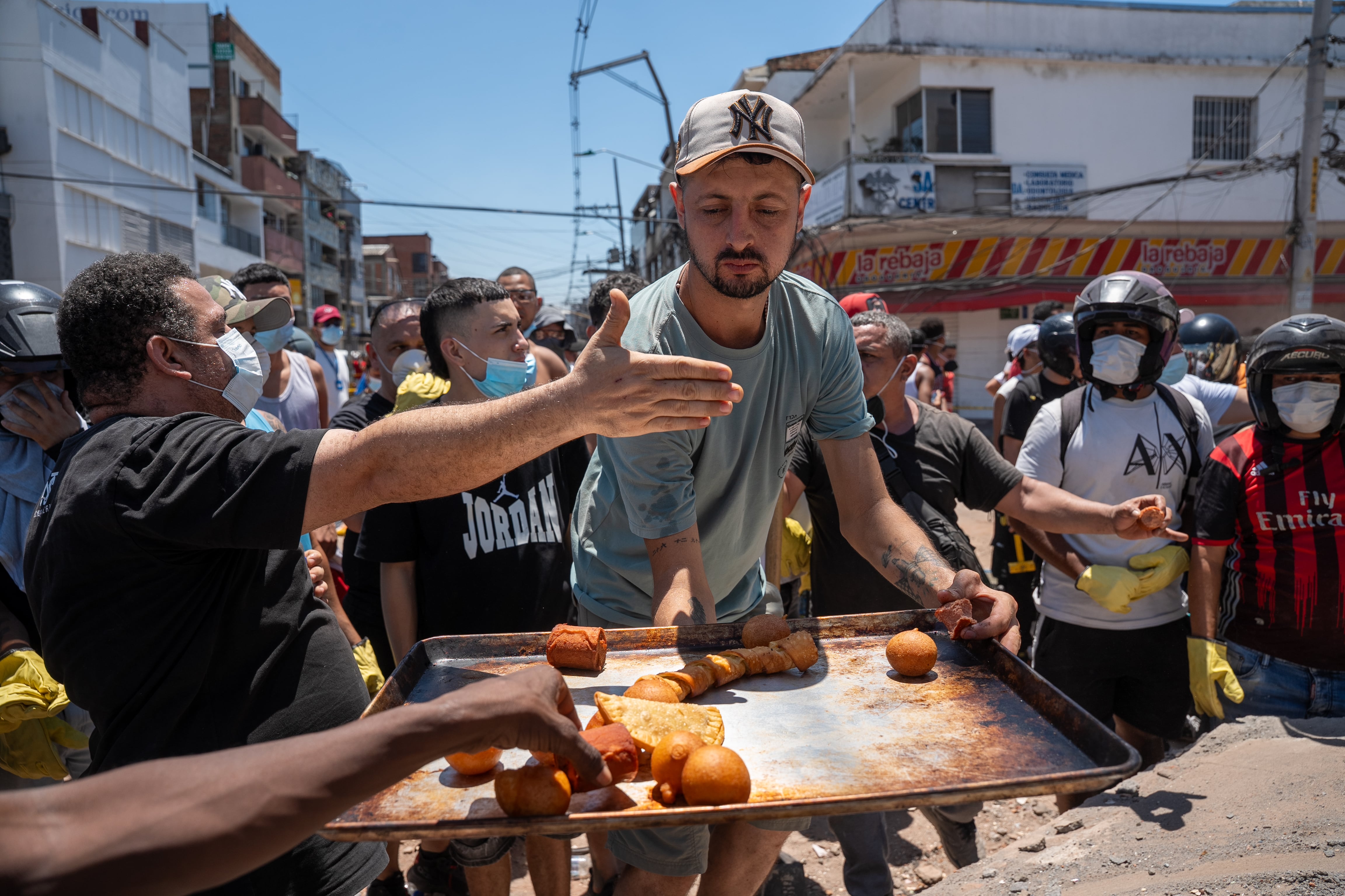 Voluntarios repaerten comida en un edificio colapsado en Barrio Alameda, en Cali.