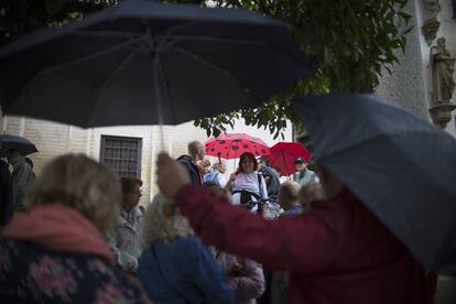 Un grupo de turistas en Sevilla se protegen de la lluvia, el 18 de octubre de 2017.
