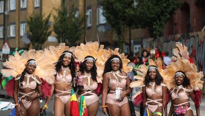 Artistas en traje posan para una fotografía antes de su aparición en el principal desfile del Carnaval de Notting Hill.