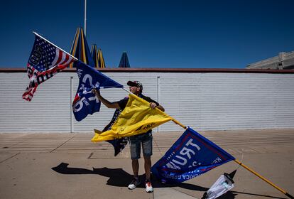 Kelly Johnson, con sus banderas a las afueras del edificio donde cuentan los votos. 
