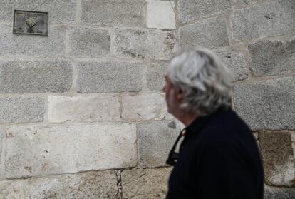 Llamazares observa una placa en la pared de la catedral que indica el comienzo del Camino de Santiago Complutense.