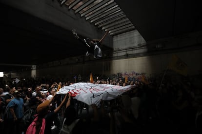 Una mujer es lanzada por los aires por varios manifestantes durante la marcha en recuerdo de la matanza de Tlatelolco, el 2 de octubre de 2018, en Ciudad de México.