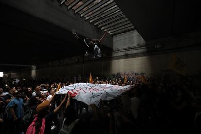 Una mujer es lanzada por los aires por varios manifestantes durante la marcha en recuerdo de la matanza de Tlatelolco, el 2 de octubre de 2018, en Ciudad de México.